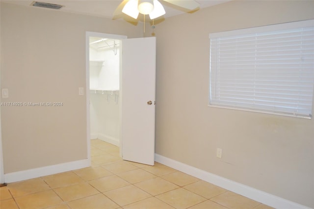 tiled empty room featuring ceiling fan