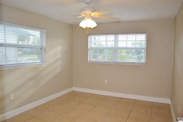 tiled spare room featuring ceiling fan