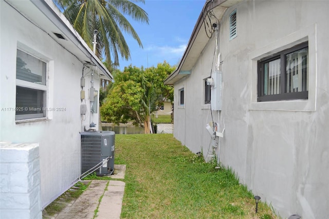 view of side of property with cooling unit and a yard