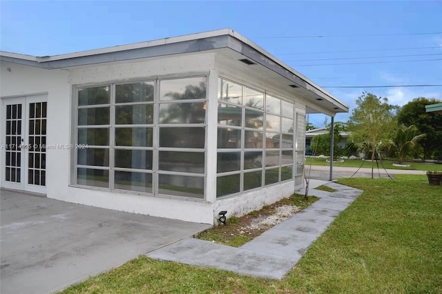 view of side of home with a yard and a patio