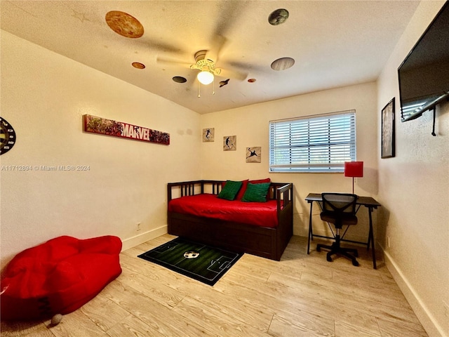 bedroom with hardwood / wood-style flooring, ceiling fan, and a textured ceiling