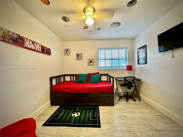 bedroom with a textured ceiling, light hardwood / wood-style flooring, and ceiling fan