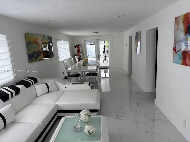 living room featuring a textured ceiling and french doors