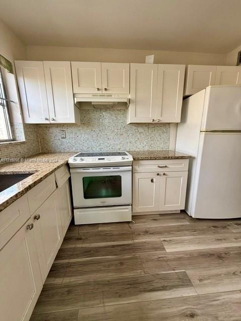 kitchen with backsplash, light stone counters, white appliances, light hardwood / wood-style flooring, and white cabinetry