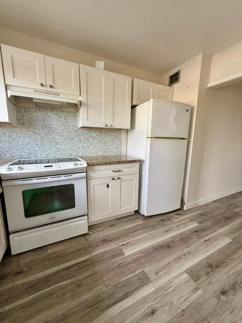 kitchen featuring white appliances, light hardwood / wood-style flooring, white cabinetry, and light stone counters