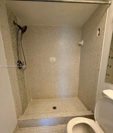 bathroom featuring toilet and tiled shower