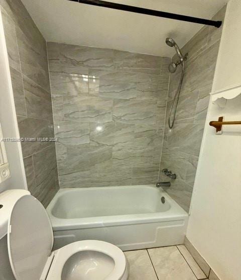 bathroom with toilet, tile patterned floors, and tiled shower / bath