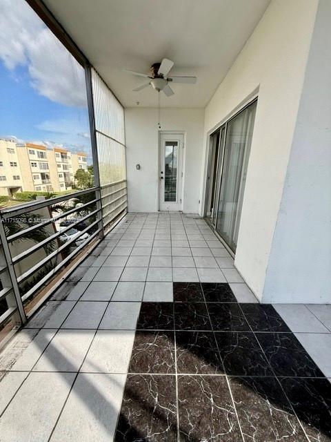 unfurnished sunroom with ceiling fan