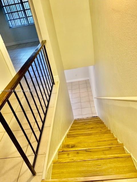 stairway with tile patterned floors