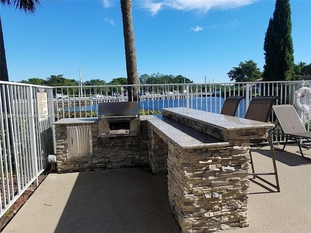 view of patio featuring area for grilling and a water view