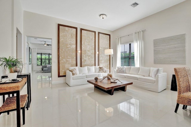 tiled living room featuring a wealth of natural light and ceiling fan