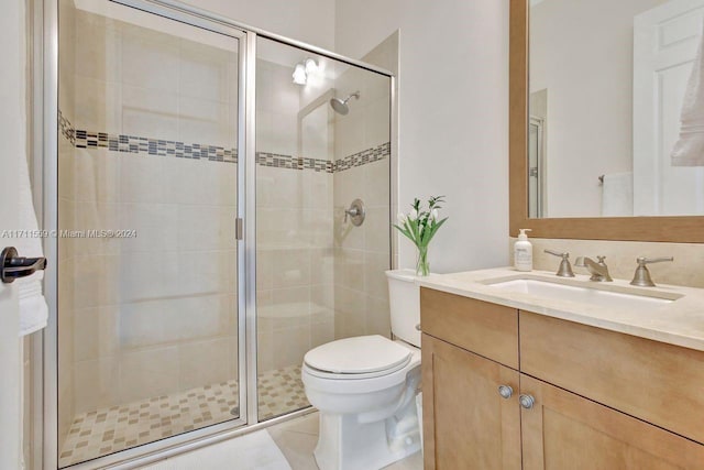 bathroom featuring tile patterned flooring, toilet, vanity, and walk in shower