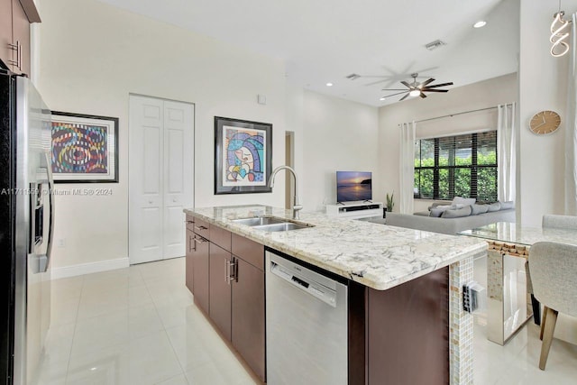 kitchen with dark brown cabinetry, sink, an island with sink, and stainless steel appliances