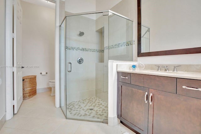 bathroom with tile patterned floors, vanity, an enclosed shower, and toilet