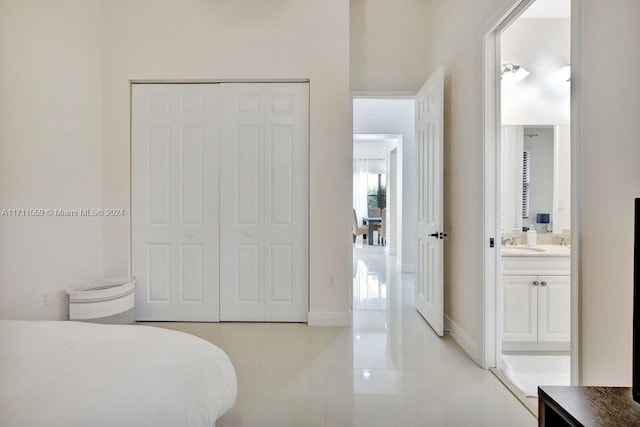 bedroom with ensuite bath, sink, and a closet