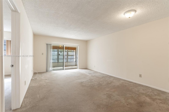 carpeted spare room with a textured ceiling