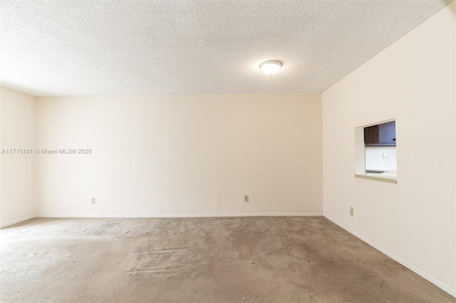 carpeted empty room with a textured ceiling