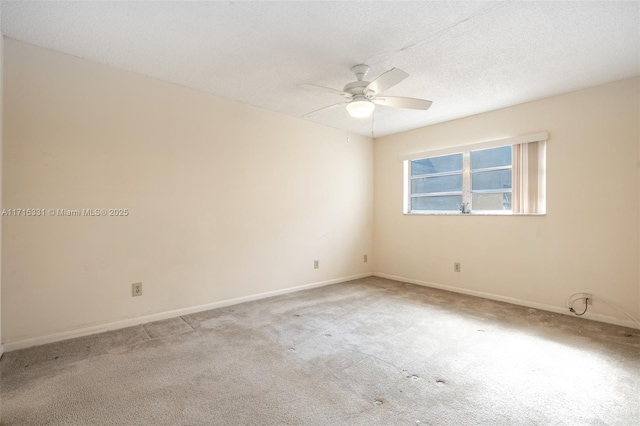 empty room featuring ceiling fan, light colored carpet, and a textured ceiling