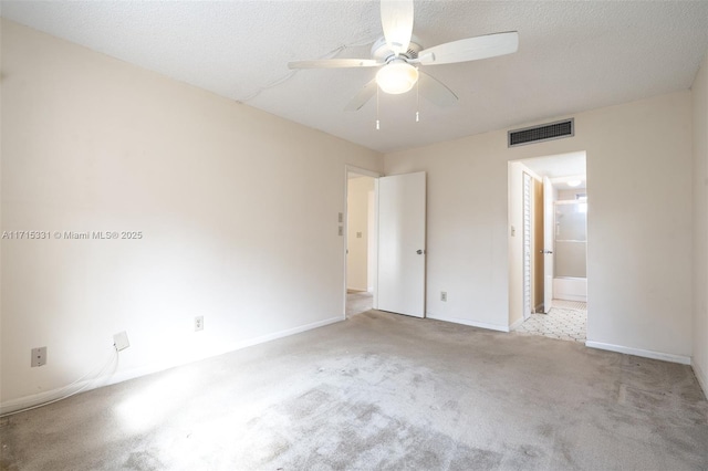 unfurnished bedroom with light carpet, a textured ceiling, ensuite bathroom, and ceiling fan