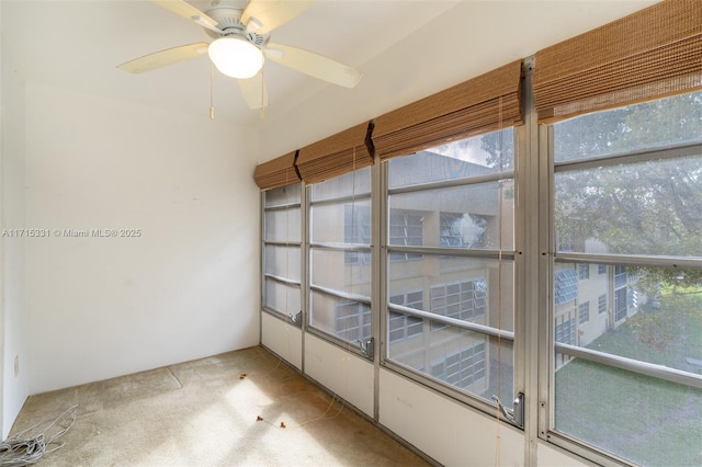 unfurnished sunroom featuring ceiling fan