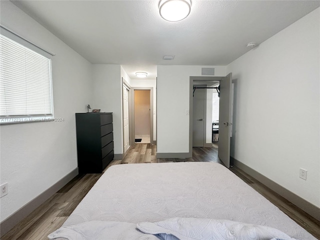 bedroom with dark wood-type flooring