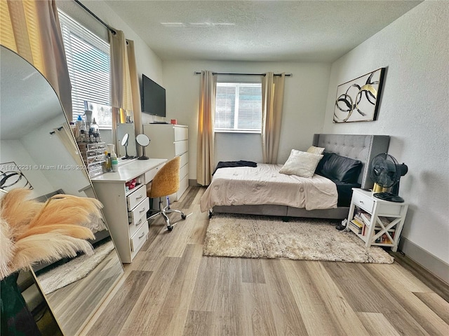 bedroom featuring light wood-type flooring and a textured ceiling