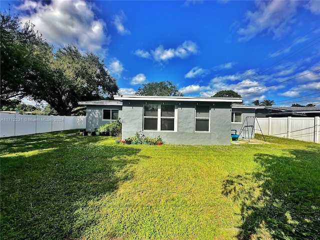 back of house with a lawn