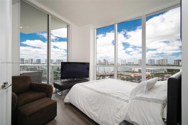 bedroom featuring floor to ceiling windows, hardwood / wood-style floors, and multiple windows