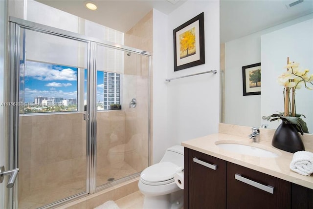 bathroom with tile patterned flooring, vanity, toilet, and a shower with shower door