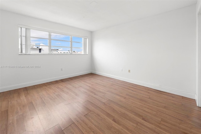 unfurnished room with wood-type flooring