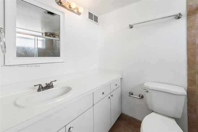 bathroom with tile patterned floors, vanity, toilet, and walk in shower