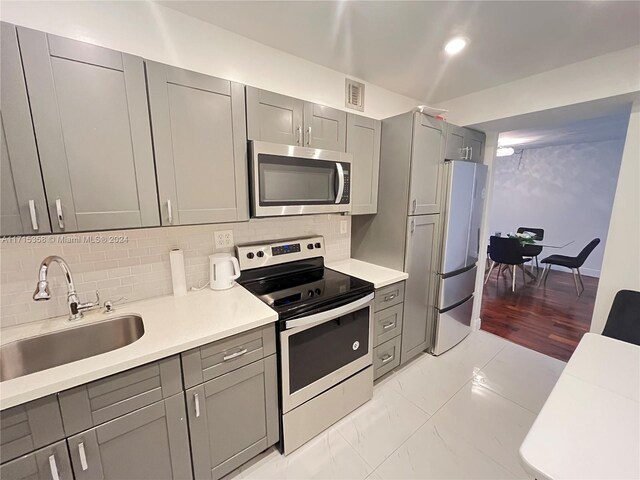 1849 S Ocean Dr Unit 409, Hallandale Beach, FL 33009 - kitchen featuring gray cabinetry, backsplash, sink, and stainless steel appliances