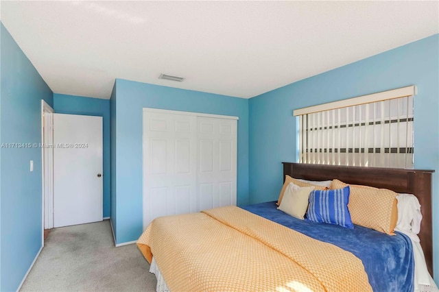 bedroom with light carpet and a closet