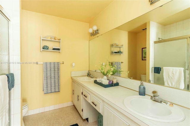 bathroom featuring tile patterned floors, vanity, toilet, and walk in shower