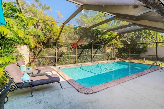 view of pool with glass enclosure and a patio area