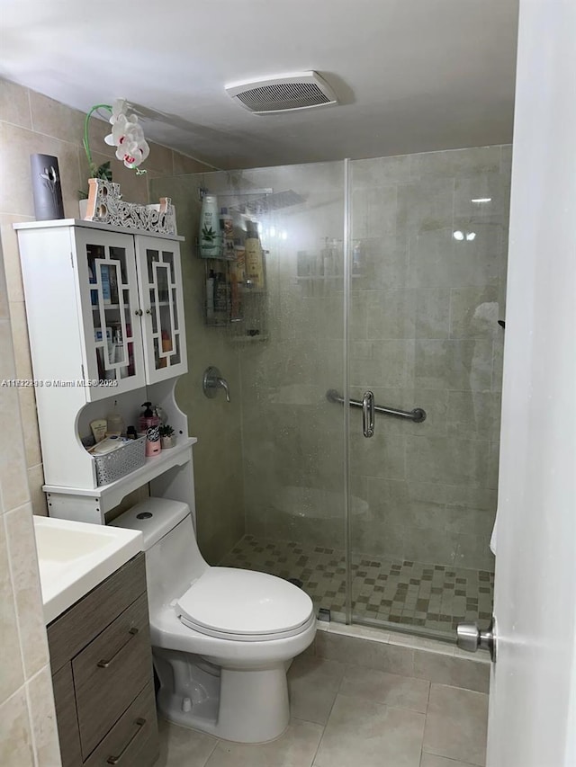 bathroom with a stall shower, visible vents, toilet, tile patterned flooring, and vanity