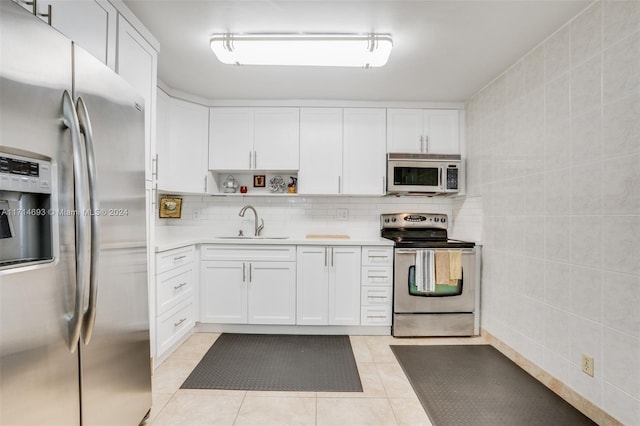 kitchen with white cabinets, light tile patterned flooring, sink, and appliances with stainless steel finishes