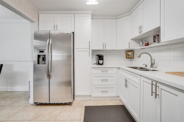 kitchen featuring white cabinets, stainless steel fridge, and sink