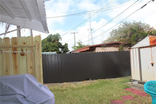 view of yard with an outbuilding, a fenced backyard, and a storage shed