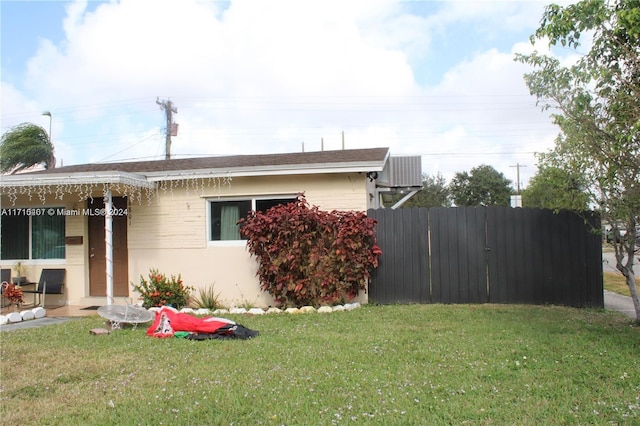 view of side of property featuring central AC unit, a lawn, and fence