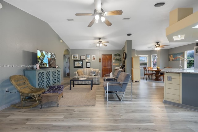 living room with vaulted ceiling, sink, and light hardwood / wood-style flooring