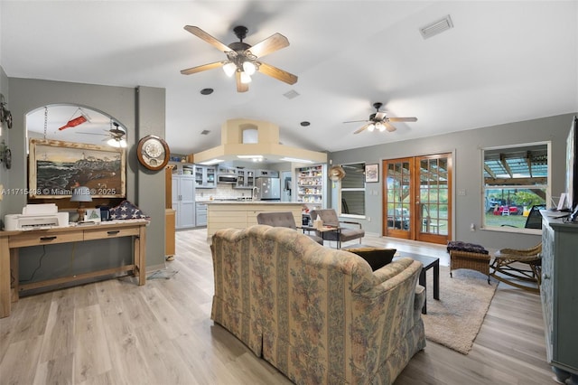 living room featuring lofted ceiling, light hardwood / wood-style floors, french doors, and ceiling fan