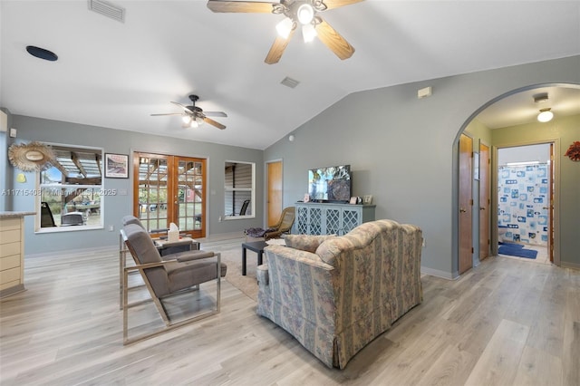 living room with ceiling fan, lofted ceiling, and light wood-type flooring