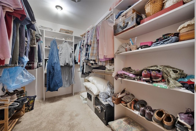 walk in closet with light carpet