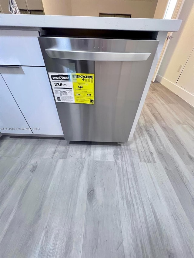 room details featuring stainless steel dishwasher and light hardwood / wood-style flooring