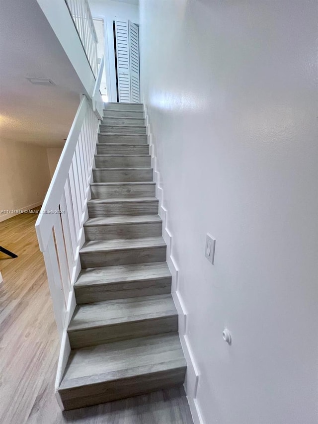 stairs featuring hardwood / wood-style flooring