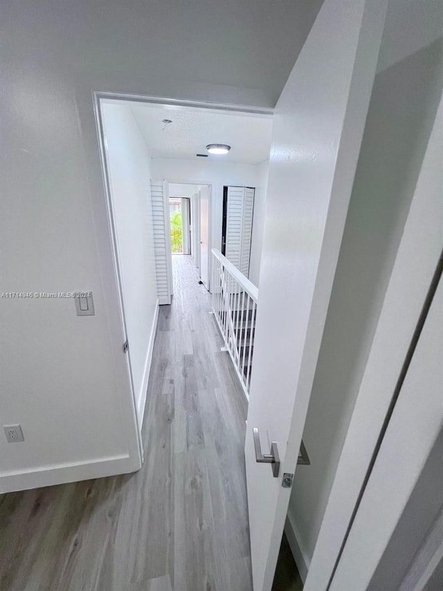 corridor with light hardwood / wood-style floors