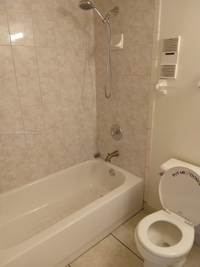 bathroom featuring tile patterned flooring, toilet, and tiled shower / bath