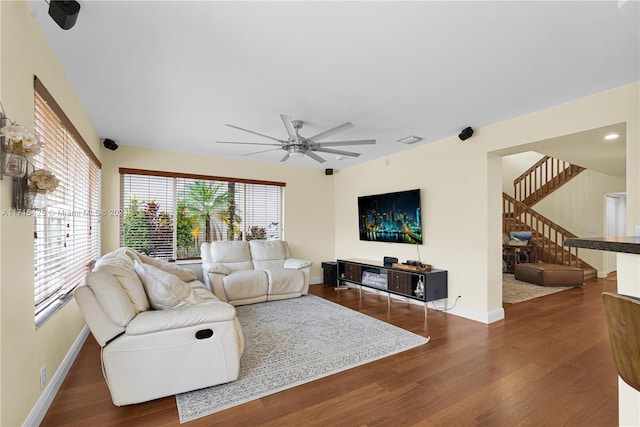 living room featuring ceiling fan and dark wood-type flooring