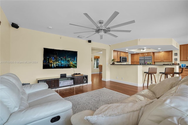 living room featuring hardwood / wood-style floors and ceiling fan